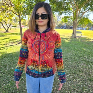 May include: A colorful hooded jacket with a sun design on the front. The jacket has a zipper closure and is made of a soft, comfortable fabric.