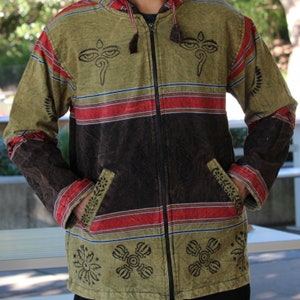 May include: A green and brown striped hooded jacket with a zipper closure. The jacket has a variety of embroidered designs, including eyes, flowers, and other symbols.