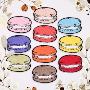 以下が含まれることがあります： ピンク、ブルー、パープル、イエロー、オレンジ、レッド、ブラウンなど、さまざまな色のマカロンの刺繍アイロン接着パッチが10個あります。各マカロンには白いフィリングがあります。