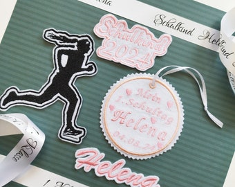 May include: A set of four pink and white embroidered patches with the text "Schulkind 2024", "Mein 1. Schultag Helena 04.08.24", "Helena", and "1. Klasse".