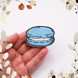 以下が含まれることがあります： アイロン接着できるマカロンの形をした薄い青色の刺繍パッチ