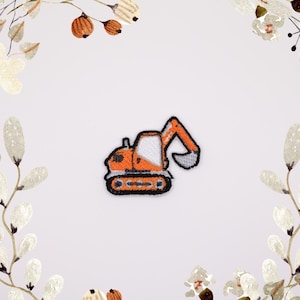 Puede incluir: Parche bordado con una excavadora naranja y blanca. El parche tiene un borde negro y está diseñado para planchar o coser sobre tela. Ideal para decorar ropa o accesorios.