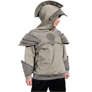 May include: A silver and gray hooded sweatshirt designed to resemble knight armor. The costume features a helmet-like hood, shoulder pads, and arm guards. The chest area has a geometric design. The bottom is black.