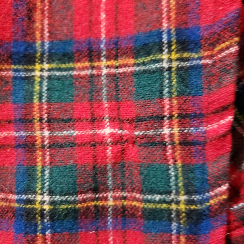 Puede incluir: Primer plano de una tela a cuadros roja, verde, azul y blanca. El patr&oacute;n presenta un dise&ntilde;o tart&aacute;n cl&aacute;sico con l&iacute;neas que se cruzan creando una apariencia de cuadr&iacute;cula. La tela tiene una superficie texturizada.