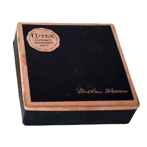 May include: A rectangular black manicure set box with a pink border. The top features a circular label with the text Cutex Compact Manicure Set and the name Northam Warren printed in script in the bottom right corner of the black surface.