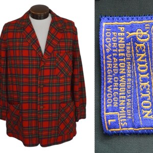 Puede incluir: Una blazer a cuadros rojos, verdes y negros con tres botones y dos bolsillos delanteros. La blazer tiene una etiqueta que dice "Pendleton Woolen Mills, Portland, Oregon, 100% Virgin Wool".