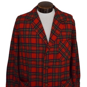 Puede incluir: Una blazer a cuadros rojos, verdes y azules con solapas con muescas, dos bolsillos delanteros y botones marrones. La chaqueta vintage se exhibe en un maniqu&iacute; y tiene un corte cl&aacute;sico y entallado.