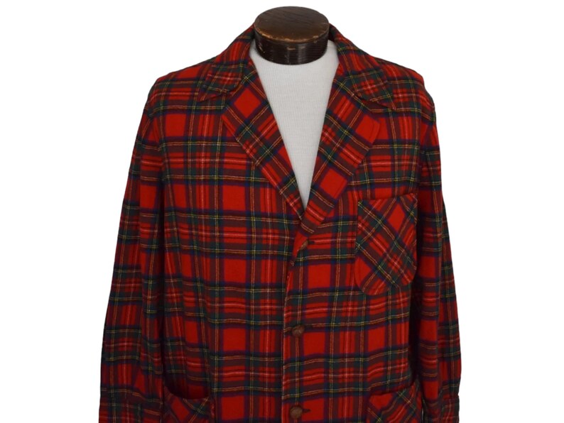 Puede incluir: Una blazer a cuadros rojos, verdes y azules con solapas con muescas, dos bolsillos delanteros y botones marrones. La chaqueta vintage se exhibe en un maniqu&iacute; y tiene un corte cl&aacute;sico y entallado.