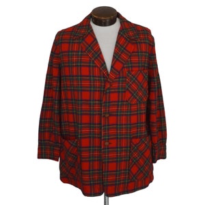 May include: A red plaid blazer with a classic design. The jacket features a traditional button closure, two front pockets, and a chest pocket. The plaid pattern includes red, green, and navy blue lines. The blazer is displayed on a mannequin.