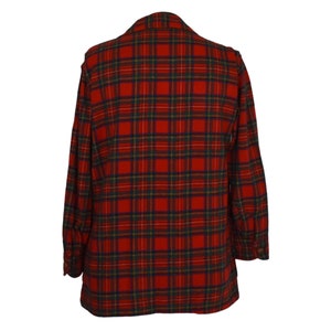 Puede incluir: Una blazer a cuadros rojos y verdes. La chaqueta presenta un patr&oacute;n de tart&aacute;n cl&aacute;sico, con una base roja, acentuada por l&iacute;neas verdes, amarillas y azul marino. La blazer tiene solapas con muescas y pu&ntilde;os abotonados, lo que sugiere un ajuste a medida.