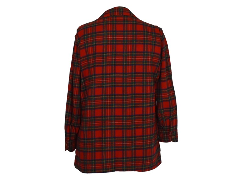 Puede incluir: Una blazer a cuadros rojos y verdes. La chaqueta presenta un patr&oacute;n de tart&aacute;n cl&aacute;sico, con una base roja, acentuada por l&iacute;neas verdes, amarillas y azul marino. La blazer tiene solapas con muescas y pu&ntilde;os abotonados, lo que sugiere un ajuste a medida.