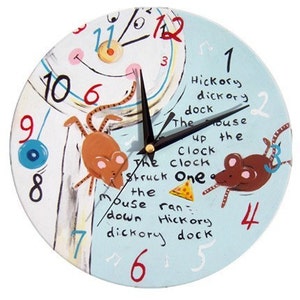 Puede incluir: Un reloj azul y blanco con un diseño pintado de ratones y una araña. La esfera del reloj tiene los números del 1 al 12 y las palabras "Hickory dickory dock" y "The house up the clock clock struck one the mouse ran down hickory dickory dock".