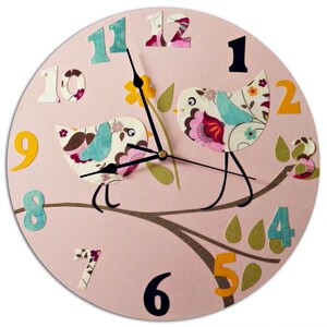 May include: Pink round clock with black hands and colorful paper bird cutouts on a branch. The numbers are in a whimsical font and are also made of paper.