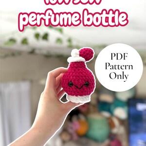 Puede incluir: Una botella de perfume hecha a mano, tejida a ganchillo, de color magenta vibrante, con una base y una parte superior blancas, y un pequeño pompón. El texto "low sew perfume bottle" se muestra encima de la botella, y "PDF Pattern Only" está en un círculo.