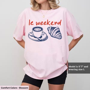 a woman wearing a pink t - shirt with a coffee cup on it
