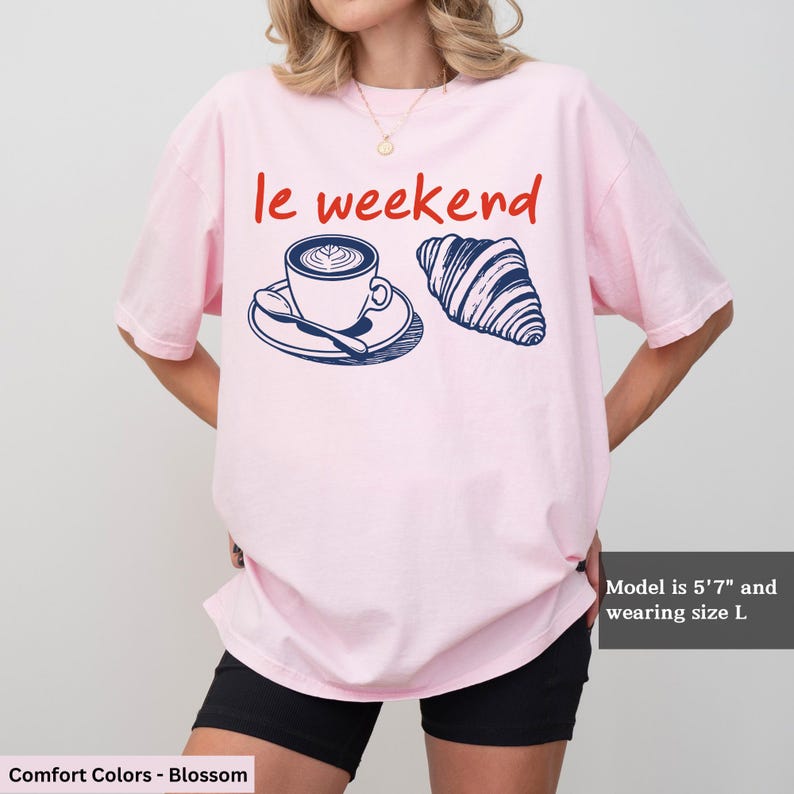 a woman wearing a pink t - shirt with a coffee cup on it