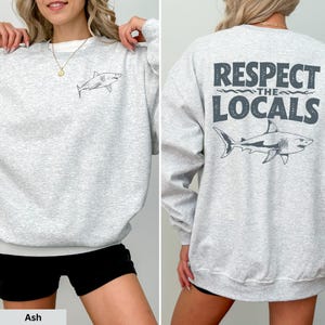 a woman wearing a sweatshirt that says respect the locals