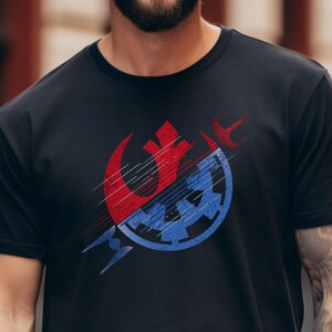 May include: A black t-shirt with a graphic of the Rebel Alliance and Imperial symbols combined in a grunge style design. The graphic is in red, blue, and white.