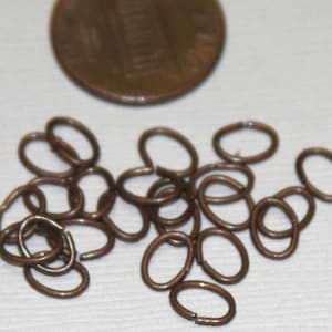 Puede incluir: Un montón de 18 pequeños anillos de salto ovalados de color cobre. Los anillos de salto tienen un diámetro de aproximadamente 1,2 cm.