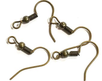 May include: A set of three antique bronze-toned metal earring hooks, each featuring a curved ear wire, a small decorative coil spring, and a round bead accent, finished with a small loop at the end for attaching jewelry components.