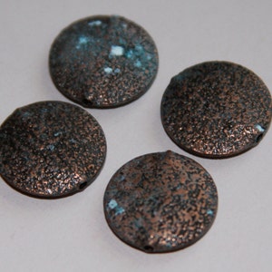 May include: Four round, copper-colored beads with a textured surface and a speckled blue and white glaze.