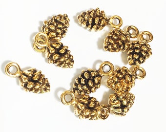 May include: A set of eight gold-toned metal pine cone charms with a loop for hanging. The charms are detailed with textured surfaces and are perfect for adding a touch of nature to jewelry or crafts.