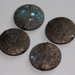 May include: Four round copper-colored beads with a textured surface and blue and white accents.