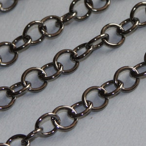 May include: A close-up of a black metal chain with round links. The chain is made of a durable metal and has a smooth, polished finish.