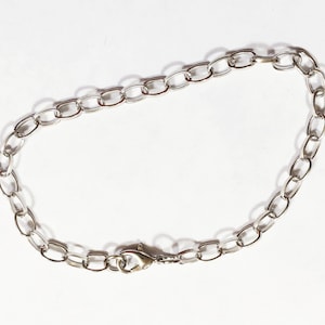 May include: A silver chain bracelet with a lobster clasp closure.