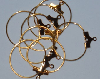 Puede incluir: Un juego de seis hallazgos de aro de pendientes de color dorado con un cierre decorativo. Los aros son de diferentes tamaños y están apilados uno encima del otro.