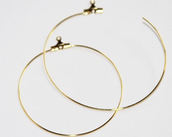 May include: Two gold hoop earrings with a clasp closure.