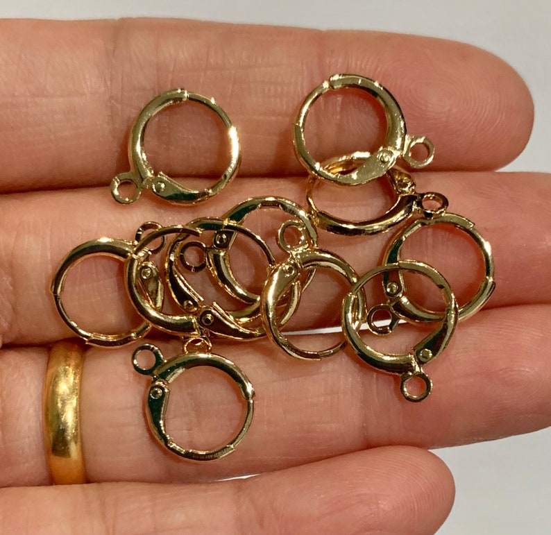 Puede incluir: Primer plano de un grupo de anillos de salto dorados. Los anillos tienen un di&aacute;metro de aproximadamente 2,5 cm y un dise&ntilde;o simple y circular.