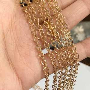 May include: A close-up of multiple strands of gold chain, likely for jewelry making. The chain is made of small, round links.