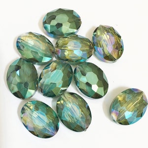 May include: Ten oval-shaped green glass beads with iridescent facets. The beads have a light green color with a hint of gold.