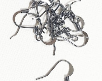 May include: A close-up of a pile of silver earring hooks. The hooks are made of metal and have a spring closure.