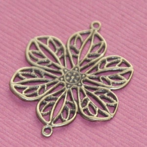 May include: A silver filigree flower charm with two loops for attaching to jewelry or other crafts.