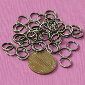 Op de afbeelding: Een stapel antieke gouden springringen, ongeveer 1,25 cm in diameter, naast een Britse penny voor een vergelijking van de grootte.