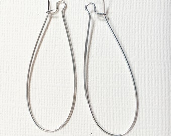 May include: Two silver teardrop-shaped earring hoops.