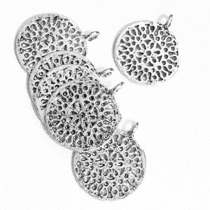 May include: A collection of silver-toned, circular pendants with intricate openwork designs. Each pendant features a small loop at the top for attaching to a chain or cord. The pendants are arranged on a white background, showcasing their detailed patterns.