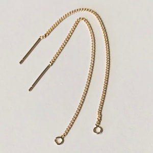 May include: Two gold chain earring extenders with jump rings at the bottom and straight posts at the top.