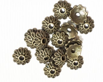May include: A group of 15 antique gold-toned metal flower-shaped bead caps. The bead caps have a decorative design and a hole in the center.