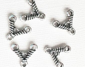 May include: Five silver-toned metal triangle connectors with three loops each. The connectors have a rope-like design.