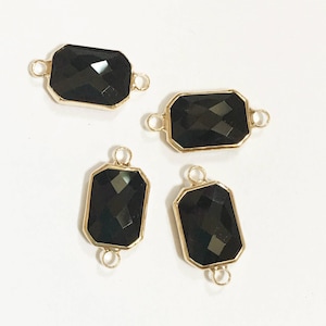 May include: Four gold-toned connectors with black faceted gemstone accents. Each connector has two loops for attaching to jewellery.