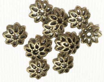 May include: A group of ten antique gold metal flower-shaped beads with a decorative openwork design.