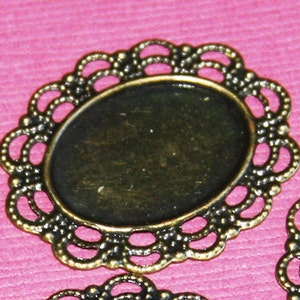 May include: A gold-toned metal oval frame with a delicate, intricate design. The frame has a raised edge and is perfect for adding a touch of elegance to crafts.