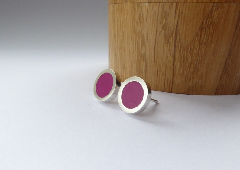 small round silver and magenta stud earrings on a white background