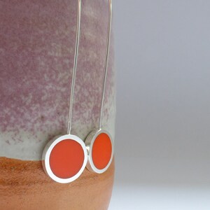 Pop long earrings in recycled Sterling SIlver hanging over the edge of a pot