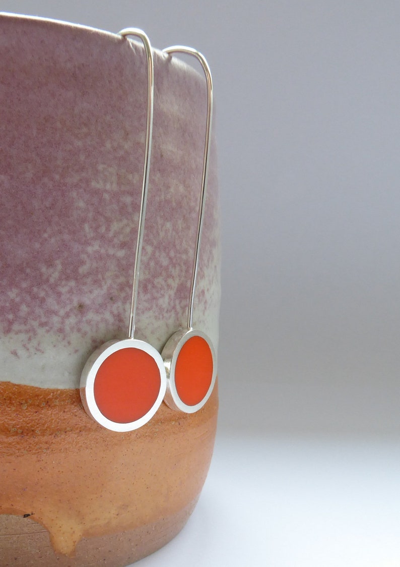 Pop long earrings in recycled Sterling SIlver hanging over the edge of a pot