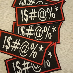 May include: Five black fabric patches with red stitching around the edges. Each patch has white embroidered text that reads "!$#@%*"