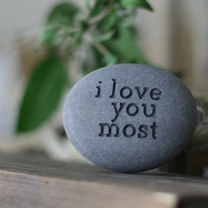 May include: A grey stone with the words "i love you most" engraved on it.